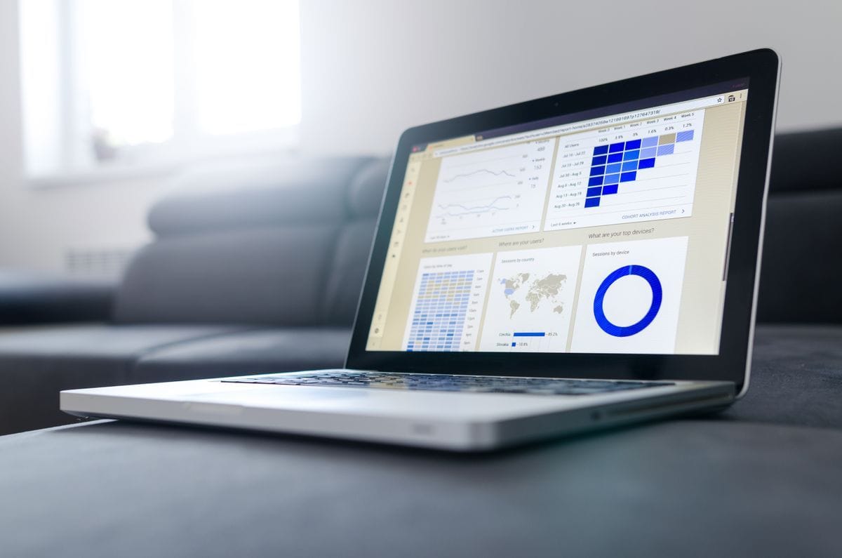 Notebook com painel de gráficos e indicadores sobre uma mesa